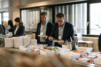 Zwei Männer befüllen ihre Teller am Buffet